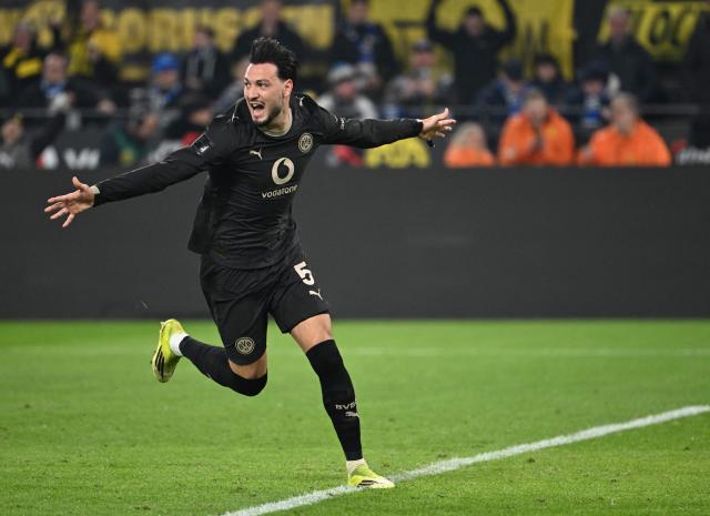 Dortmund's Algerian defender #05 Ramy Bensebaini celebrates his 1-2 after a penalty shot, during the German first division Bundesliga football match between Borussia Dortmund and HSV Hamburg in Dortmund, western Germany, on March 21, 2026. (Photo by UWE KRAFT / AFP) / DFL REGULATIONS PROHIBIT ANY USE OF PHOTOGRAPHS AS IMAGE SEQUENCES AND/OR QUASI-VIDEO