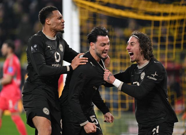 Dortmund's Portuguese forward #21 Fabio Silva (R) celebrates his 2-2 with Dortmund's German midfielder #08 Felix Nmecha (L) and Dortmund's Algerian defender #05 Ramy Bensebaini during the German first division Bundesliga football match between Borussia Dortmund and HSV Hamburg in Dortmund, western Germany, on March 21, 2026. (Photo by UWE KRAFT / AFP) / DFL REGULATIONS PROHIBIT ANY USE OF PHOTOGRAPHS AS IMAGE SEQUENCES AND/OR QUASI-VIDEO