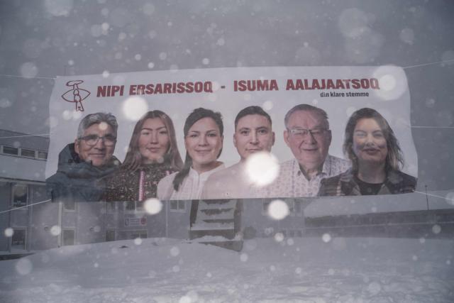 This image shows a poster of the Greenlandic Social Democratic party Inuit Ataqatigiit being tossed by the wind during a snowstorm in Nuuk, Greenland, on March 21, 2026. As early legislative elections are being held in Denmark on March 24, Greenland will also have to vote to elect two representatives to the Danish parliament. (Photo by Florent VERGNES / AFP)