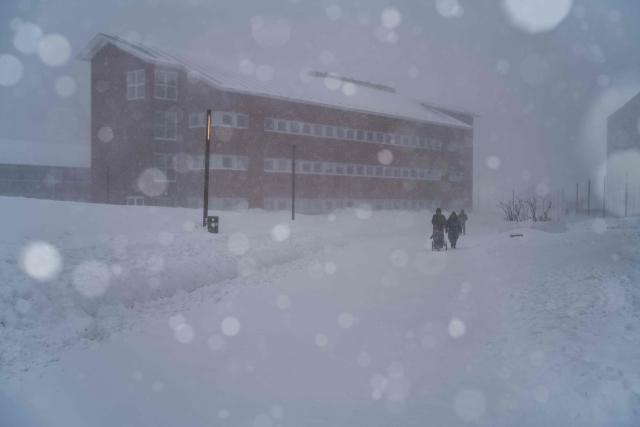 Two people walk through the streets during a snowstorm, in Nuuk, Greenland, on March 21, 2026. (Photo by Florent VERGNES / AFP)