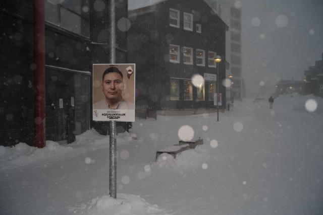 This image shows a poster of a candidate from the Greenlandic Social Democratic party Inuit Ataqatigiit, plastered on a pole during a snowstorm, in Nuuk, Greenland, on March 21, 2026. As early legislative elections are being held in Denmark on March 24, Greenland will also have to vote to elect two representatives to the Danish parliament. (Photo by Florent VERGNES / AFP)