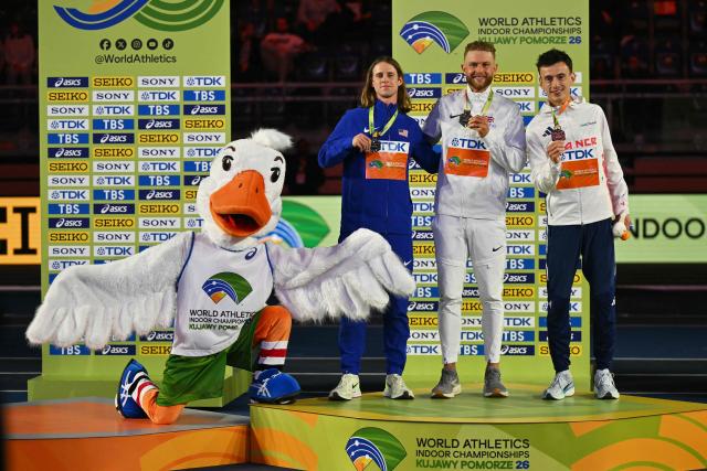 Silver medallist USA's Cole Hocker (2ndL), gold medallist Britain's Josh Kerr and Bronze medallist France's Yann Schrub celebrate with medals on the podium for the men's 3000 metres event during the World Athletics Indoor Championships Kujawy Pomorze 2026 in Torun, Poland on March 21, 2026. (Photo by Andrej ISAKOVIC / AFP)