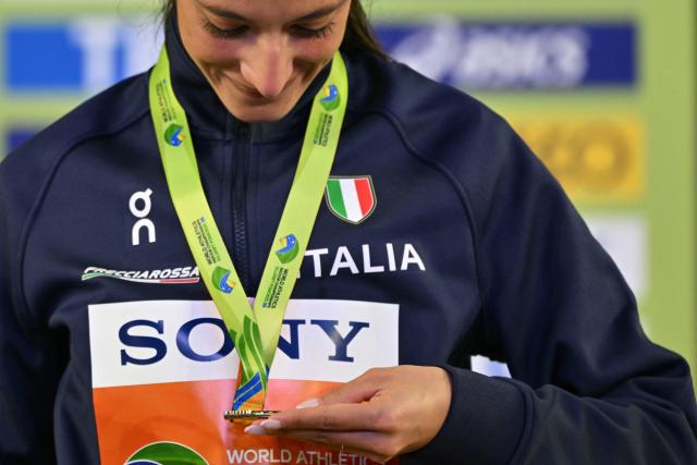 Gold medallist Italy's Nadia Battocletti celebrates on the podium for the women's 3000 metres event during the World Athletics Indoor Championships Kujawy Pomorze 2026 in Torun, Poland on March 21, 2026. (Photo by Andrej ISAKOVIC / AFP)