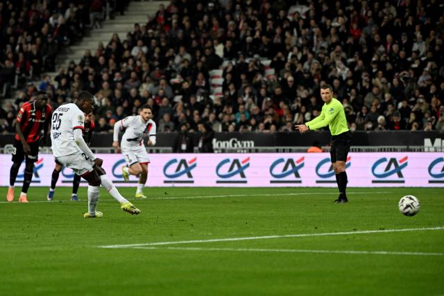 Paris Saint-Germain's Portuguese defender #25 Nuno Mendes takes a penalty shot to score a goal during the French L1 football match between OGC Nice and Paris Saint-Germain at the Allianz Riviera stadium in Nice, southern France, on March 21, 2026. (Photo by Miguel MEDINA / AFP)