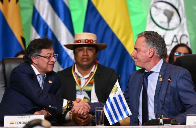 Colombia's President Gustavo Petro (L) shakes hands with Uruguay's President Yamandu Orsi during the X Summit of Heads of State and Government, within the framework of the CELAC-Africa High-Level Forum, in Bogota on March 21, 2026. (Photo by Raul ARBOLEDA / AFP)