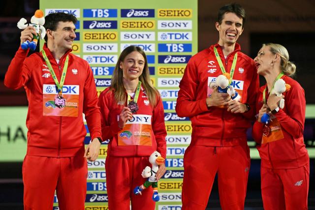Bronze medallists Poland's Marcin Karolewski (L), Poland's Anna Gryc, Poland's Kajetan Duszynski and Poland's Justyna Swiety-Ersetic celebrate on the podium for the 4x400 relay during the World Athletics Indoor Championships Kujawy Pomorze 2026 in Torun, Poland on March 21, 2026. (Photo by Andrej ISAKOVIC / AFP)