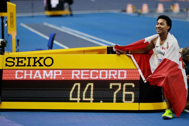 Canada's Christopher Morales Williams celebrates by the clock after setting a championship record time after the men's heptathlon 400m final 2 during the World Athletics Indoor Championships Kujawy Pomorze 2026 in Torun, Poland on March 21, 2026. (Photo by Wojtek RADWANSKI / AFP)