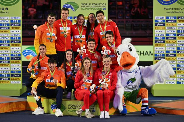 Belgium gold medallists, Spain's sliver medallists and Poland's bronze medallists celebrate on the podium for the 4x400 relay during the World Athletics Indoor Championships Kujawy Pomorze 2026 in Torun, Poland on March 21, 2026. (Photo by Andrej ISAKOVIC / AFP)