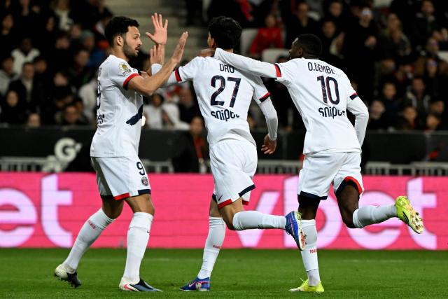 Paris Saint-Germain's Spanish midfielder #27 Dro Fernandez (C) celebrates with team mates Paris Saint-Germain's Portuguese forward #09 Goncalo Ramos (L) and Paris Saint-Germain's French forward #10 Ousmane Dembele (R) after scoring a goal during the French L1 football match between OGC Nice and Paris Saint-Germain at the Allianz Riviera stadium in Nice, southern France, on March 21, 2026. (Photo by Miguel MEDINA / AFP)