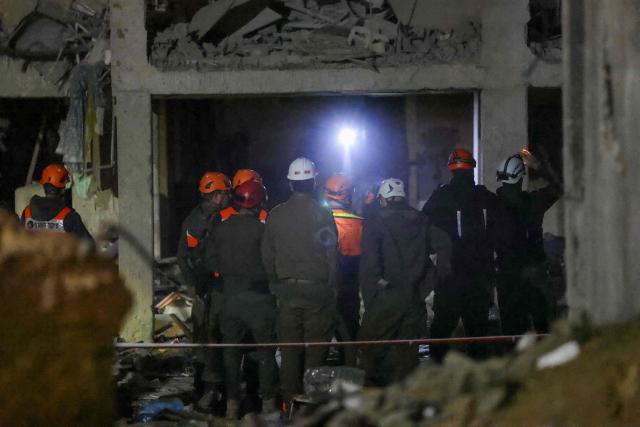 TOPSHOT - First responders inspect the site of an Iranian missile strike in Arad early on March 22, 2026. Israeli medics said 59 people were wounded in an Iranian missile strike March 21 on the southern town of Arad, raising initial casualty figures. (Photo by Ilia YEFIMOVICH / AFP) / 