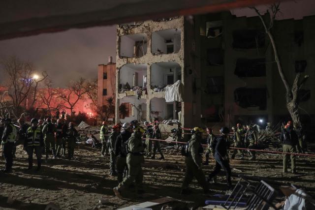 First responders inspect the site of an Iranian missile strike in Arad early on March 22, 2026. Iranian missile strikes on two southern Israeli towns wounded more than 100 people on March 21, medics said, after Israeli air defence systems failed to intercept the projectiles. (Photo by Ilia YEFIMOVICH / AFP) / 