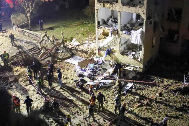 First responders inspect the site of an Iranian missile strike in Arad early on March 22, 2026. Iranian missile strikes on two southern Israeli towns wounded more than 100 people on March 21, medics said, after Israeli air defence systems failed to intercept the projectiles. (Photo by Ilia YEFIMOVICH / AFP) / 