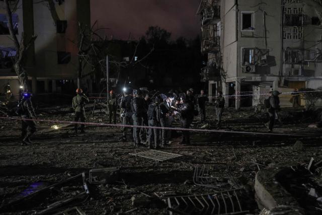 TOPSHOT - First responders inspect the site of an Iranian missile strike in Arad early on March 22, 2026. Iranian missile strikes on two southern Israeli towns wounded more than 100 people on March 21, medics said, after Israeli air defence systems failed to intercept the projectiles. (Photo by Ilia YEFIMOVICH / AFP) / 