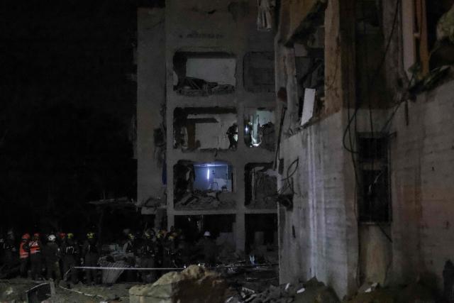 First responders inspect the site of an Iranian missile strike in Arad early on March 22, 2026. Iranian missile strikes on two southern Israeli towns wounded more than 100 people on March 21, medics said, after Israeli air defence systems failed to intercept the projectiles. (Photo by Ilia YEFIMOVICH / AFP) / 