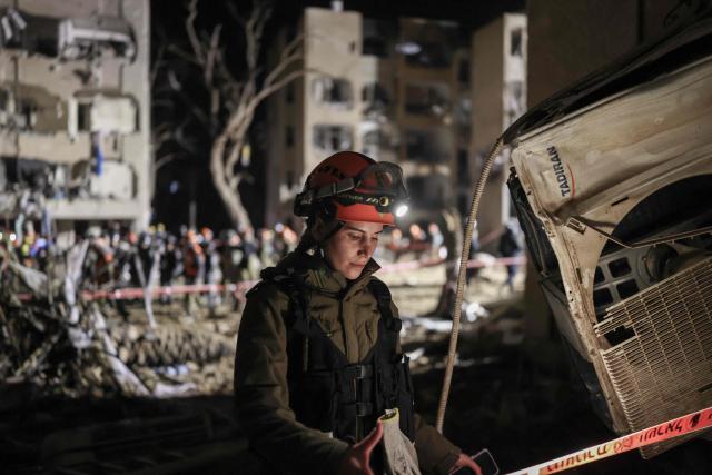 A first responders inspects the site of an Iranian missile strike in Arad early on March 22, 2026. Iranian missile strikes on two southern Israeli towns wounded more than 100 people on March 21, medics said, after Israeli air defence systems failed to intercept the projectiles. (Photo by Ilia YEFIMOVICH / AFP) / 