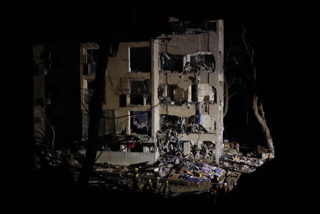 First responders inspect the site of an Iranian missile strike in Arad early on March 22, 2026. Iranian missile strikes on two southern Israeli towns wounded more than 100 people on March 21, medics said, after Israeli air defence systems failed to intercept the projectiles. (Photo by Ilia YEFIMOVICH / AFP) / 