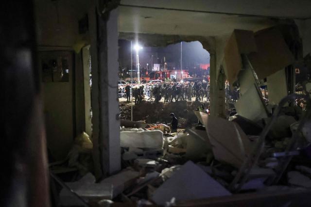 First responders inspect the site of an Iranian missile strike in Arad early on March 22, 2026. Iranian missile strikes on two southern Israeli towns wounded more than 100 people on March 21, medics said, after Israeli air defence systems failed to intercept the projectiles. (Photo by Ilia YEFIMOVICH / AFP) / 