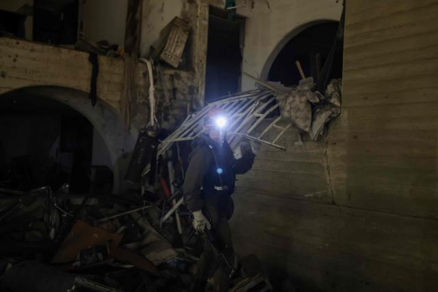 A first responders inspects the site of an Iranian missile strike in Arad early on March 22, 2026. Iranian missile strikes on two southern Israeli towns wounded more than 100 people on March 21, medics said, after Israeli air defence systems failed to intercept the projectiles. (Photo by Ilia YEFIMOVICH / AFP) / 