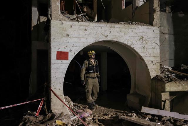A first responders inspects the site of an Iranian missile strike in Arad early on March 22, 2026. Iranian missile strikes on two southern Israeli towns wounded more than 100 people on March 21, medics said, after Israeli air defence systems failed to intercept the projectiles. (Photo by Ilia YEFIMOVICH / AFP) / 
