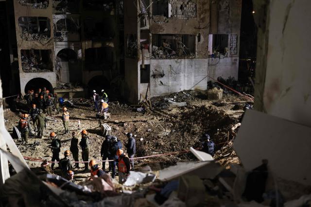 First responders inspect the site of an Iranian missile strike in Arad early on March 22, 2026. Iranian missile strikes on two southern Israeli towns wounded more than 100 people on March 21, medics said, after Israeli air defence systems failed to intercept the projectiles. (Photo by Ilia YEFIMOVICH / AFP) / 