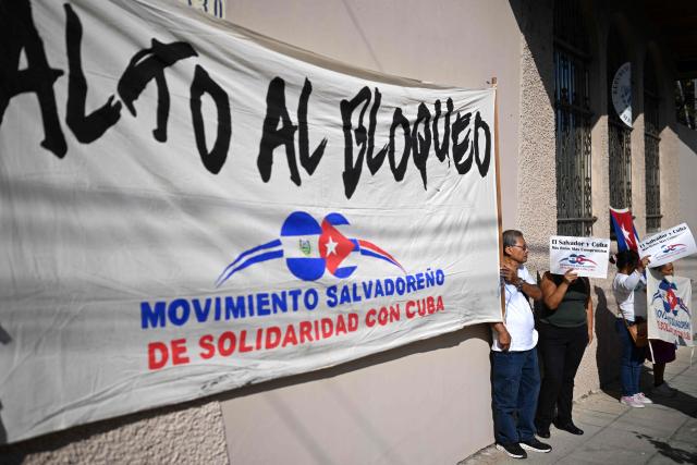 A Sign that reads 'stop the blockage' is pictured during a demonstration in solidarity with Cuba and against the US embargo, under the slogan “Cuba is not a threat,” outside the Cuban embassy in San Salvador, on March 21, 2026. AFP (Photo by Marvin RECINOS / AFP)