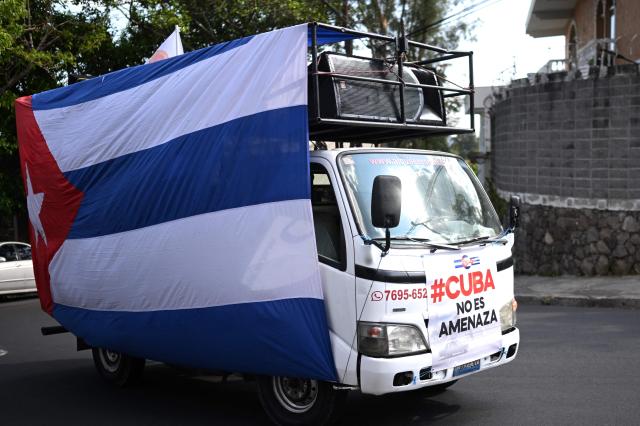 A truck covered with a Cuban flag is pictured during a demonstration in solidarity with Cuba and against the US embargo, under the slogan “Cuba is not a threat,” outside the Cuban embassy in San Salvador on March 21, 2026. (Photo by Marvin RECINOS / AFP)