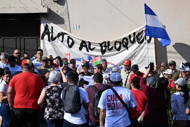 People attend a demonstration in solidarity with Cuba and against the US embargo, under the slogan “Cuba is not a threat,” outside the Cuban embassy in San Salvador on March 21, 2026. (Photo by Marvin RECINOS / AFP)