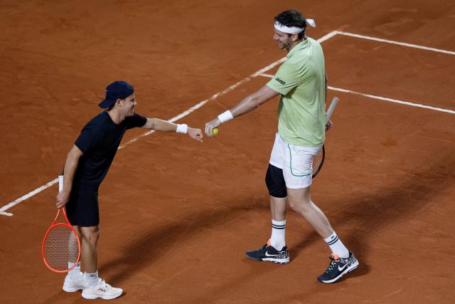 Argentina's former tennis players Diego Schwartzman (L) and Juan Martin Del Potro celebrate a point during an exhibition match against Brazil's former player Fernando Meligeni and US former player Andrew Roddick ahead of the Latin America Open Tournament in Sao Paulo, Brazil on March 21, 2026. (Photo by Miguel SCHINCARIOL / AFP)