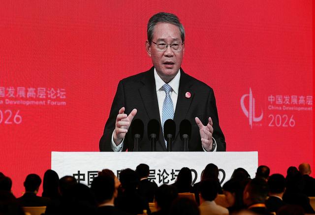 Chinese Premier Li Qiang is seen on a big screen live broadcasting his speech at the opening of the China Development Forum 2026 held at the Diaoyutai State Guesthouse in Beijing on March 22, 2026. (Photo by Ng Han Guan / POOL / AFP)