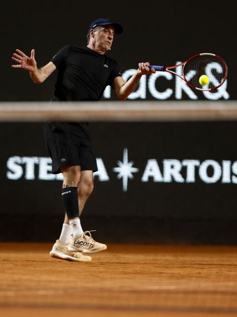Brazil's former tennis player Fernando Meligeni returns during an exhibition match against Argentina's former tennis players Diego Schwartzman (L) and Juan Martin Del Potro ahead of the Latin America Open Tournament in Sao Paulo, Brazil on March 21, 2026. (Photo by Miguel SCHINCARIOL / AFP)