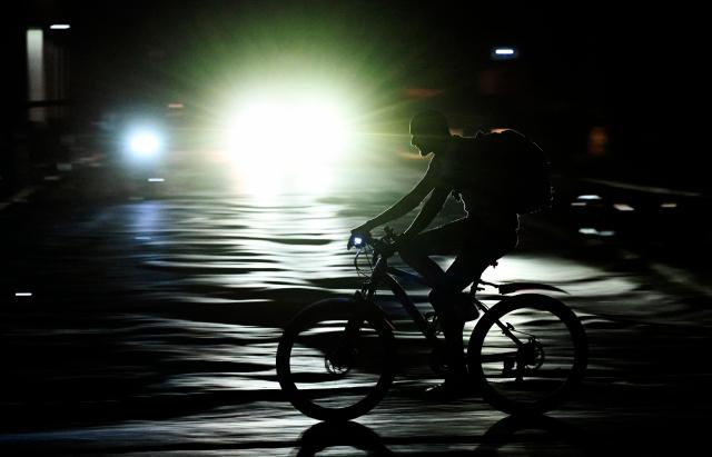 A man rides his bike during a nation wide blackout in Havana on March 21, 2026. A power outage struck the entire island of Cuba on March 21, 2026, the energy ministry said, in the second nationwide blackout in less than a week as its grid struggles under a US oil blockade. (Photo by Yamil LAGE / AFP)