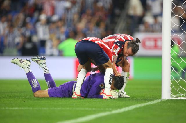 Guadalajara's goalkeeper #01 Raul Rangel is congratulated by teammates after stopping a last minute penalty kick to win the Liga MX Clausura football match between Monterrey and Guadalajara at the BBVA Stadium in Monterrey, Mexico, on March 21, 2026. (Photo by Julio Cesar AGUILAR / AFP)