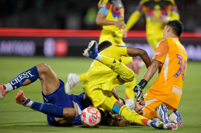 Pumas' forward #09 Guillermo Martinez (bottom) is fouled by America's Colombian defender #26 Cristian Borja to be awarded a penalty kick during the Liga MX Clausura match between Pumas and America at Olimpico Universitario Stadium in Mexico City on March 21, 2026. (Photo by Alfredo ESTRELLA / AFP)