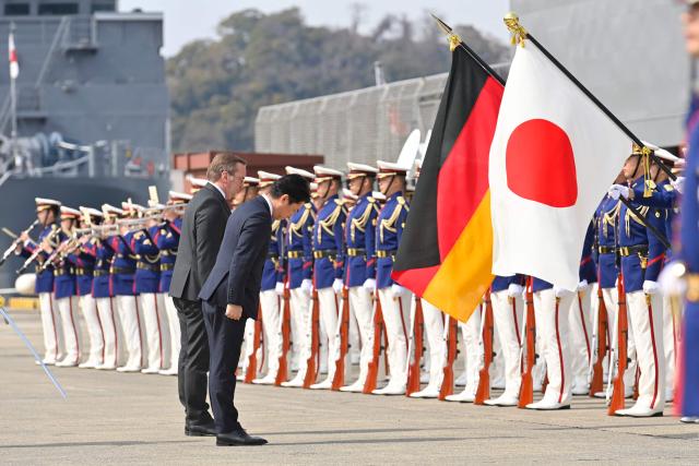 German Defence Minister Boris Pistorius and Japan's Defence Minister Shinjiro Koizumi inspect the honour guard during a welcome ceremony at the Japan Maritime Self-Defence Force (JMSDF)'s naval base in Yokosuka, south of Tokyo on March 22, 2026. (Photo by David MAREUIL / POOL / AFP)