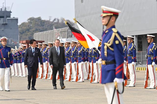 German Defence Minister Boris Pistorius and Japan's Defence Minister Shinjiro Koizumi inspect the honour guard during a welcome ceremony at the Japan Maritime Self-Defence Force (JMSDF)'s naval base in Yokosuka, south of Tokyo on March 22, 2026. (Photo by David MAREUIL / POOL / AFP)