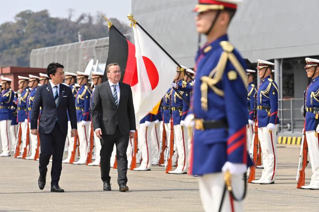 German Defence Minister Boris Pistorius and Japan's Defence Minister Shinjiro Koizumi inspect the honour guard during a welcome ceremony at the Japan Maritime Self-Defence Force (JMSDF)'s naval base in Yokosuka, south of Tokyo on March 22, 2026. (Photo by David MAREUIL / POOL / AFP)