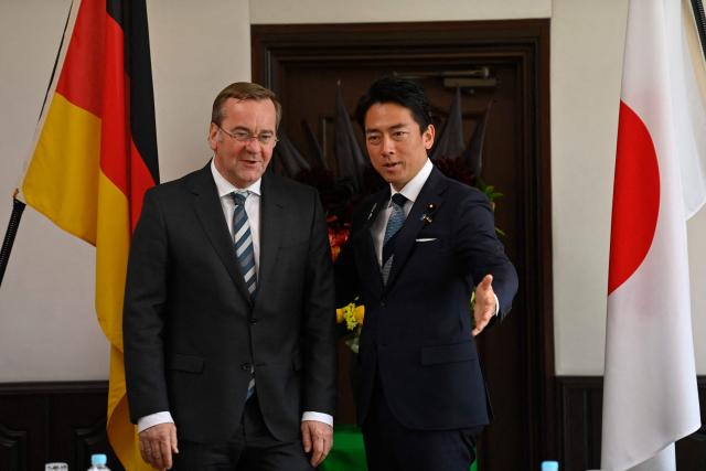 German Defence Minister Boris Pistorius (L) is welcomed by his Japan's counterpart Shinjiro Koizumi (R) prior to their meeting at the Japan Maritime Self-Defence Force (JMSDF)'s naval base in Yokosuka, south of Tokyo on March 22, 2026. (Photo by Ng Han Guan / POOL / AFP)