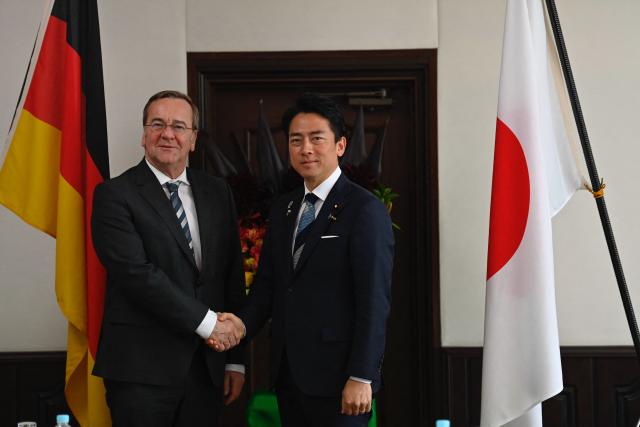 German Defence Minister Boris Pistorius (L) is welcomed by his Japan's counterpart Shinjiro Koizumi (R) prior to their meeting at the Japan Maritime Self-Defence Force (JMSDF)'s naval base in Yokosuka, south of Tokyo on March 22, 2026. (Photo by Ng Han Guan / POOL / AFP)