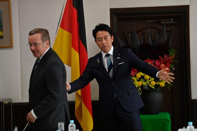 German Defence Minister Boris Pistorius (L) is welcomed by his Japan's counterpart Shinjiro Koizumi (R) prior to their meeting at the Japan Maritime Self-Defence Force (JMSDF)'s naval base in Yokosuka, south of Tokyo on March 22, 2026. (Photo by Ng Han Guan / POOL / AFP)