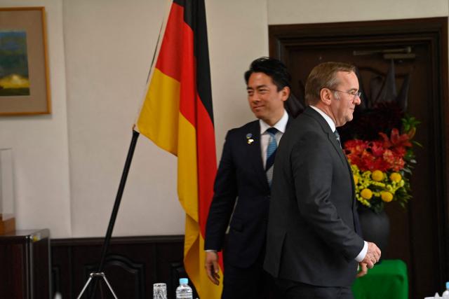 German Defence Minister Boris Pistorius (L) is welcomed by his Japan's counterpart Shinjiro Koizumi (R) prior to their meeting at the Japan Maritime Self-Defence Force (JMSDF)'s naval base in Yokosuka, south of Tokyo on March 22, 2026. (Photo by Ng Han Guan / POOL / AFP)