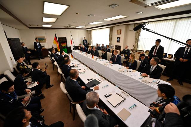 Japanese Defence Minister Shinjiro Koizumi (center-L) talks with his German counterpart Boris Pistorius (center-R) during their meeting at the Japan Maritime Self-Defence Force (JMSDF)'s naval base in Yokosuka, south of Tokyo on March 22, 2026. (Photo by Ng Han Guan / POOL / AFP)