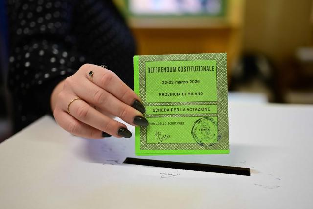 A woman casts her ballot in a polling station to vote for the Italian constitutional referendum on justice reform, in Milan, on March 22, 2026. (Photo by Piero CRUCIATTI / AFP)