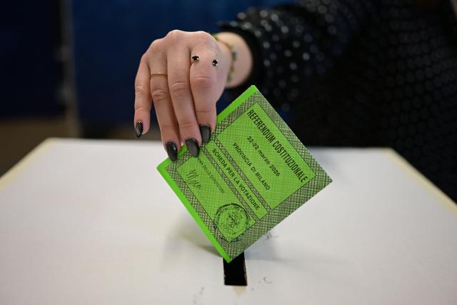 A woman casts her ballot in a polling station to vote for the Italian constitutional referendum on justice reform, in Milan, on March 22, 2026. (Photo by Piero CRUCIATTI / AFP)