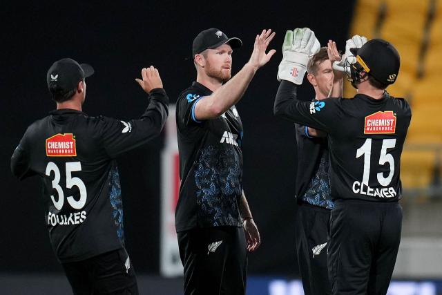 New Zealand captain Jimmy Neesham (C) celebrates catching South Africa's Tony de Zorzi with teammates during the fourth Twenty20 international cricket match between New Zealand and South Africa in Wellington on March 22, 2026. (Photo by Marty MELVILLE / AFP)