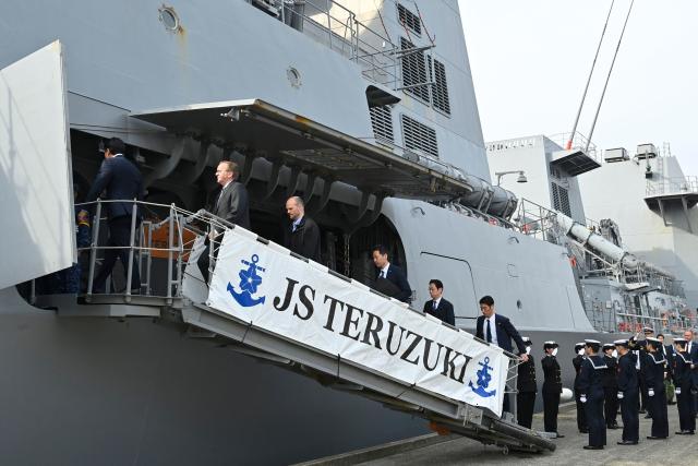 Germany's Defence Minister Boris Pistorius (2nd L) and Japan's Defence Minister Shinjiro Koizumi (1st L) board the Japan Maritime Self-Defense Force (JMSDF) destroyer JS Teruzuki (DD 116) for an inspection visit following their bilateral meeting at the JMSDF's naval base in Yokosuka, south of Tokyo on March 22, 2026. (Photo by David Mareuil / POOL / AFP)
