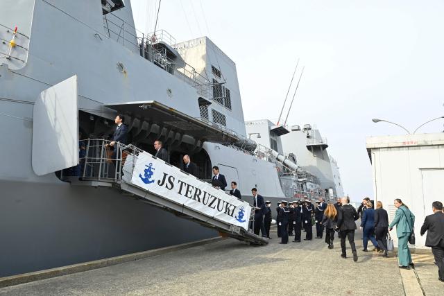 Germany's Defence Minister Boris Pistorius (2nd L) and Japan's Defence Minister Shinjiro Koizumi (1st L) board the Japan Maritime Self-Defense Force (JMSDF) destroyer JS Teruzuki (DD 116) for an inspection visit following their bilateral meeting at the JMSDF's naval base in Yokosuka, south of Tokyo on March 22, 2026. (Photo by David Mareuil / POOL / AFP)