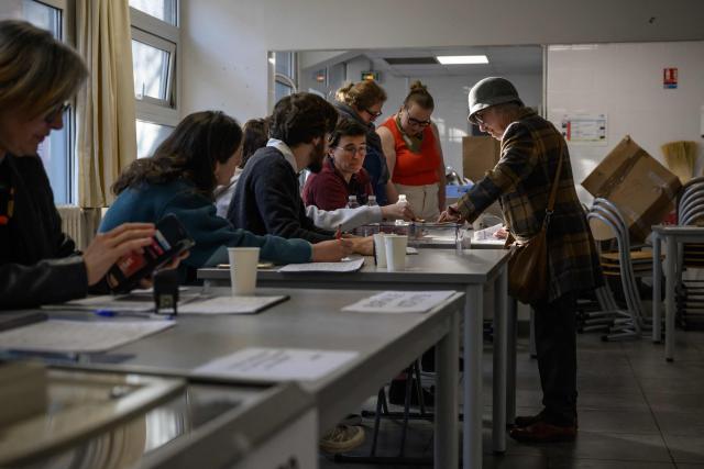 Officials look on as a voter casts their ballot during the second round of France's 2026 municipal elections in Toulouse, south-western France on March 22, 2026. (Photo by Ed JONES / AFP)