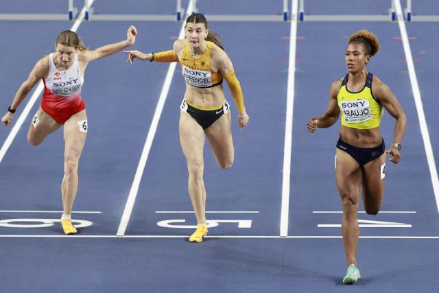 Poland's Adrianna Sulek-Schubert (L), Germany's Sandrina Sprengel and Colombia's Martha Araujo cross the finish line in the women's pentathlon 60 metres hurdles heat 1 during the World Athletics Indoor Championships Kujawy Pomorze 2026 in Torun, Poland on March 22, 2026. (Photo by Wojtek RADWANSKI / AFP)