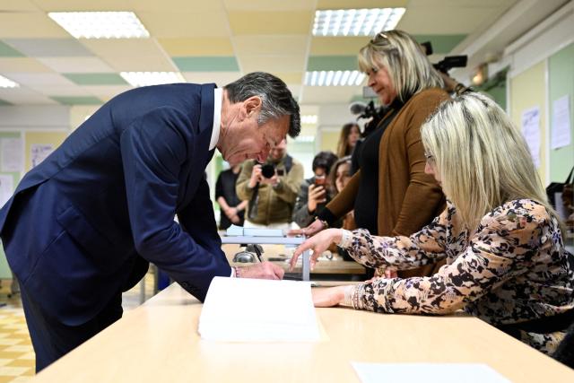 Nice's incumbent mayor and Horizons and Les Republicains (LR) candidate for re-election Christian Estrosi signs an electoral register after casting his ballot during the second round of France's 2026 municipal elections in Nice, southeastern France on March 22, 2026. (Photo by Frederic DIDES / AFP)