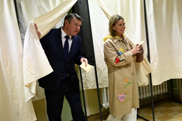 Nice's incumbent mayor and Horizons and Les Republicains (LR) candidate for re-election Christian Estrosi (L) leaves the polling booth before casting his ballot during the second round of France's 2026 municipal elections in Nice, southeastern France on March 22, 2026. (Photo by Frederic DIDES / AFP)